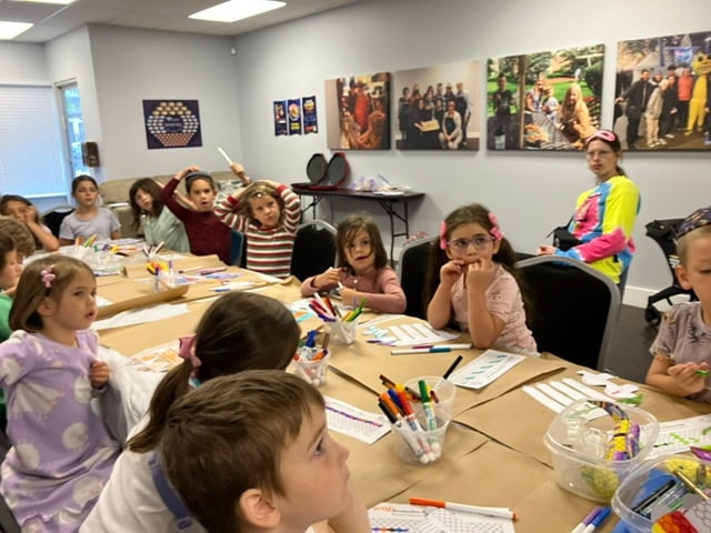Campers gathered around a hands-on cooking activity table